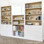 White painted DIY built in storage cabinets with natural wood inside.