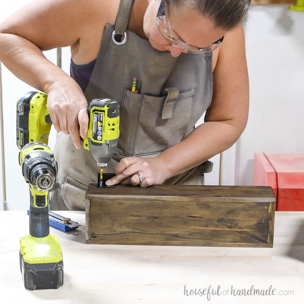 Attaching square hangers to the back of the wood bin. 