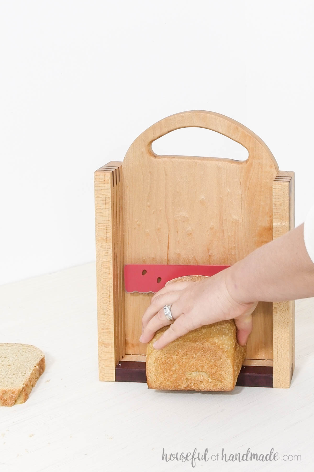 Cutting a slice of bread in a vertical bread slicer. 