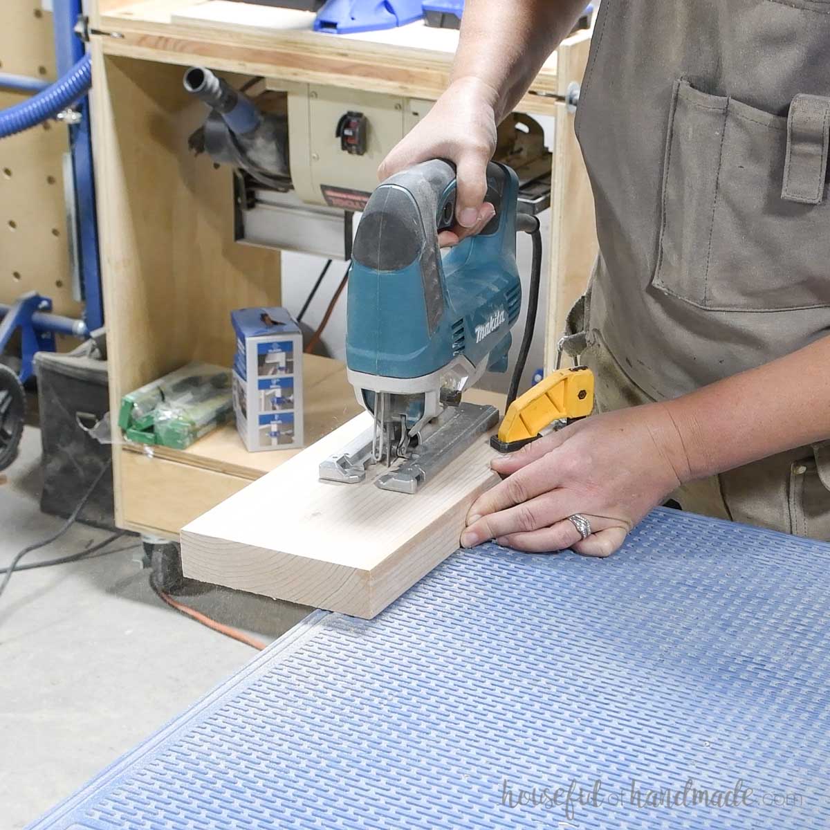 Cutting a curve on a board with a jigsaw. 