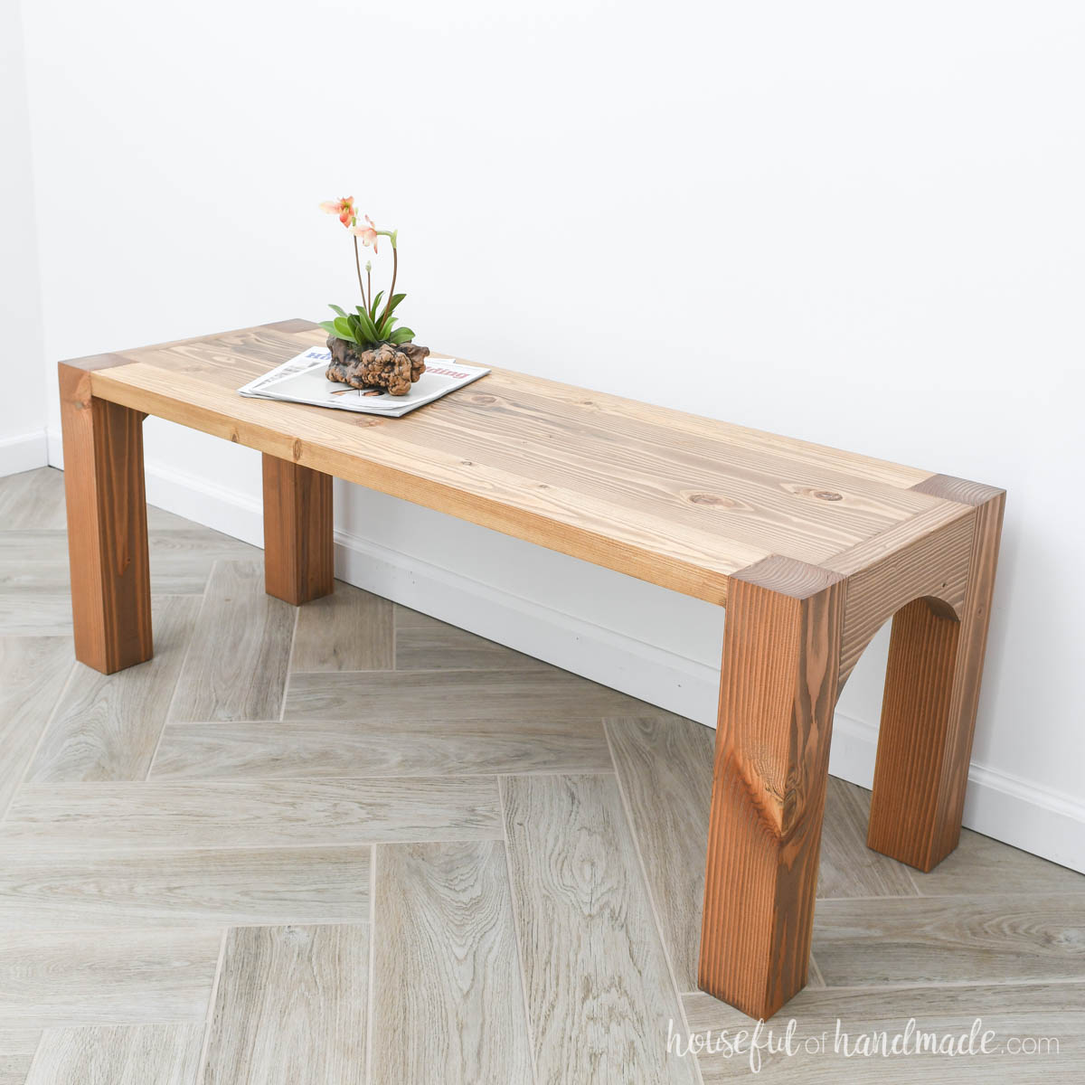 Wood coffee table with legs that show on top and arches on the sides.