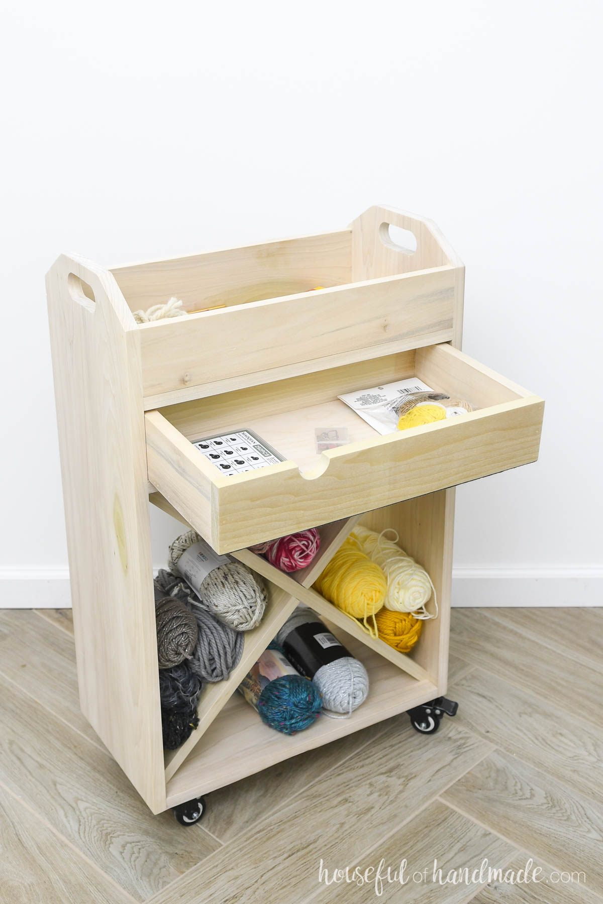 Wood craft cart with drawer open and crochet supplies in side it. 