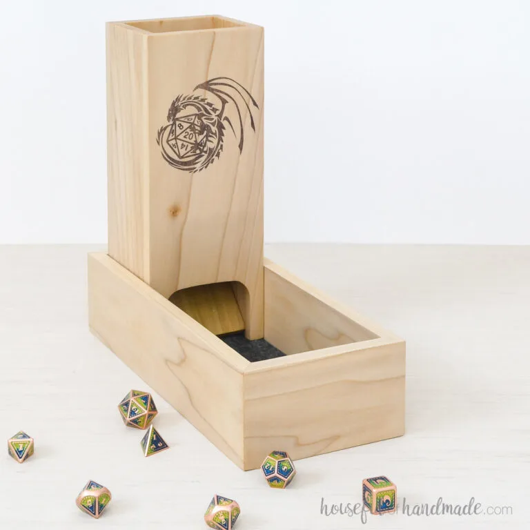 DIY dice tower made from poplar with a design on the front inside a tray.