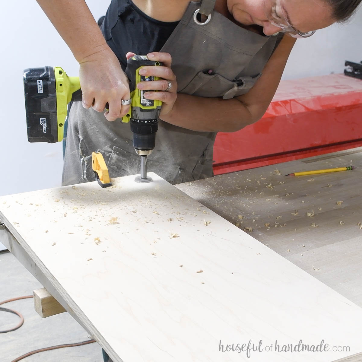 Drilling a hole in the cabinet door to use as a handle. 