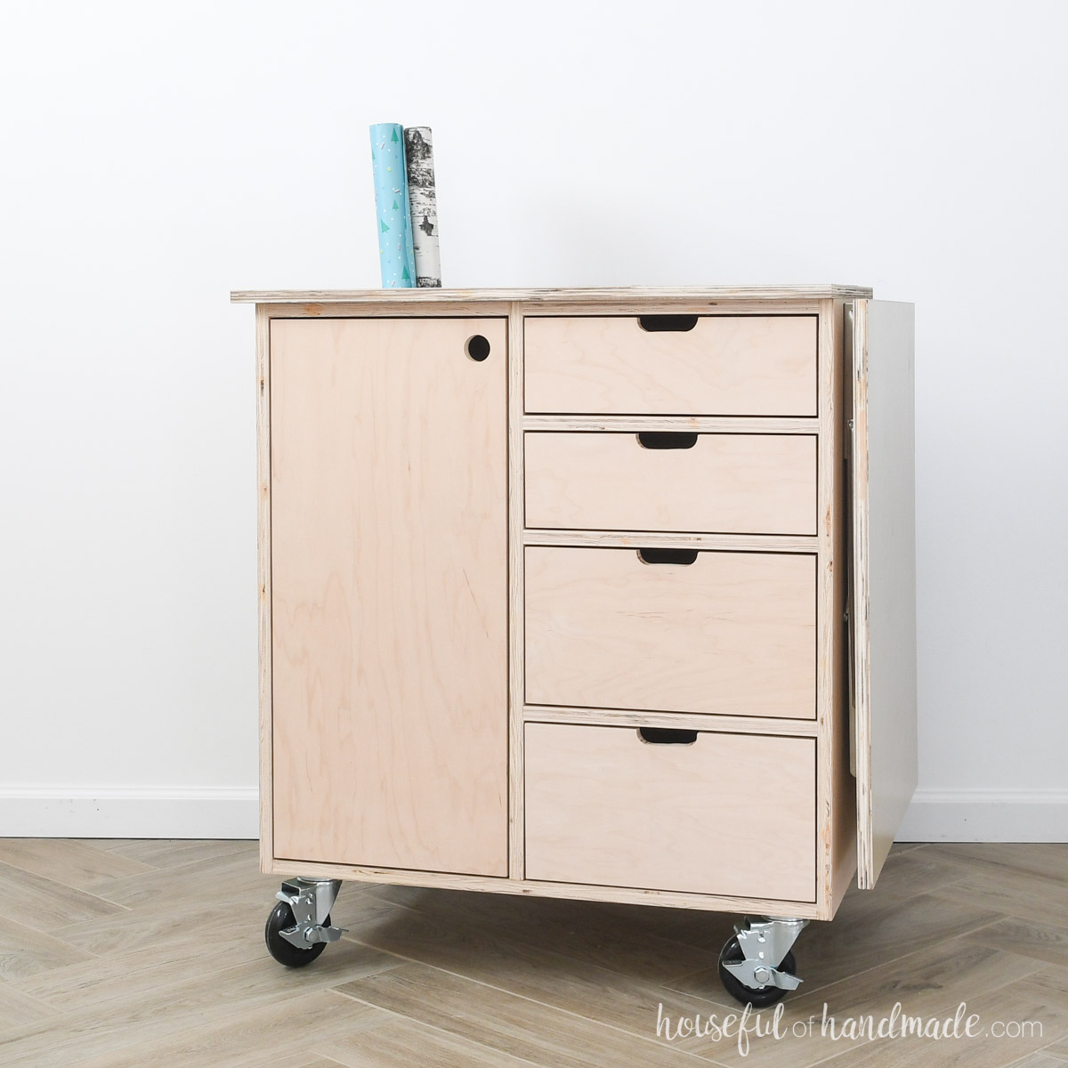 Wood wrapping paper storage with leaf on the side for a place to wrap presents. 