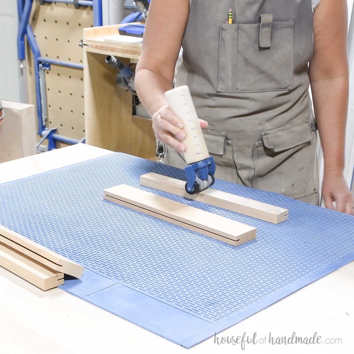 Adding glue to a board with a glue bottle.