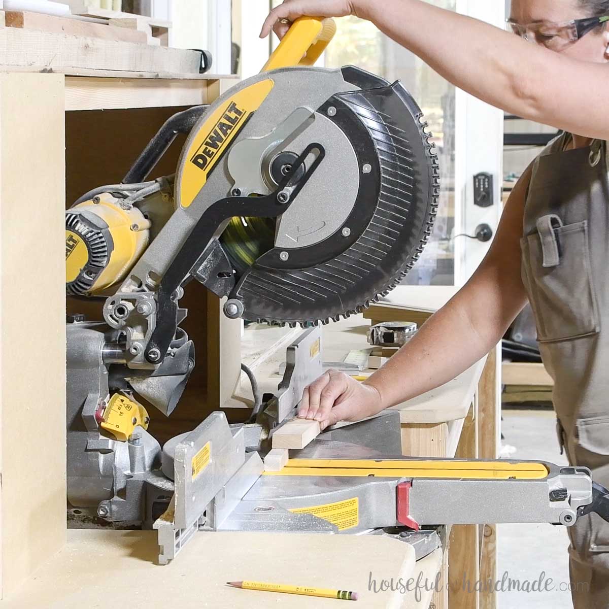 Using a scrap wood to hold a small piece of wood to cut on the miter saw. 