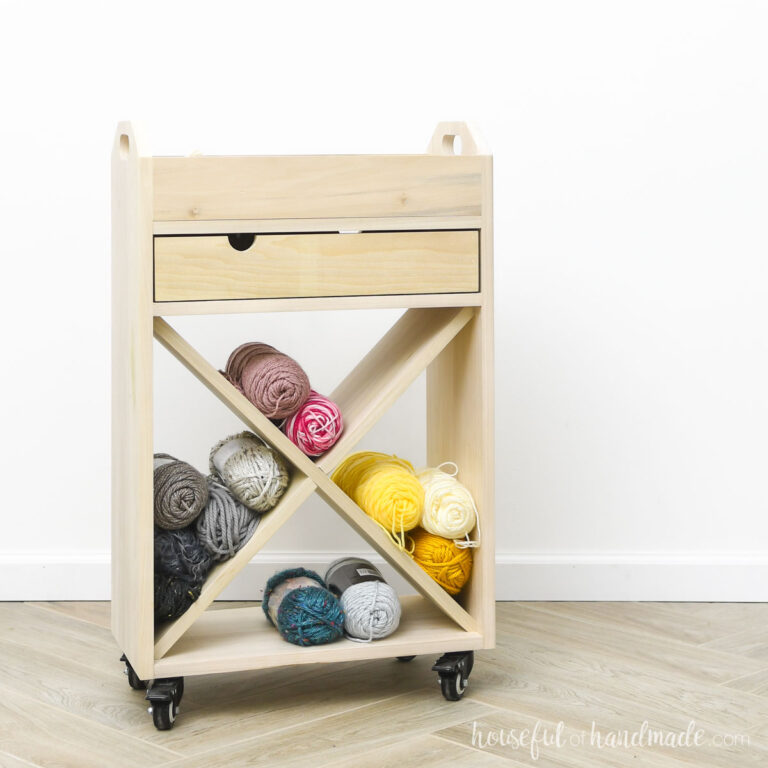 DIY wood craft cart with craft supplies stored in it.