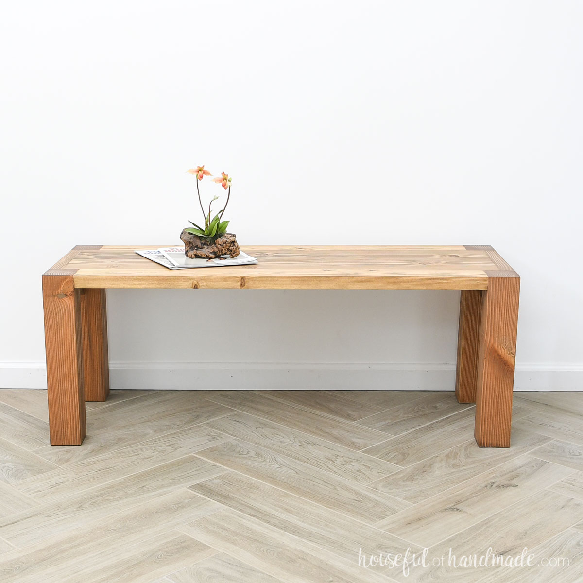 Stained wood coffee table with chunky legs cut into the top. 