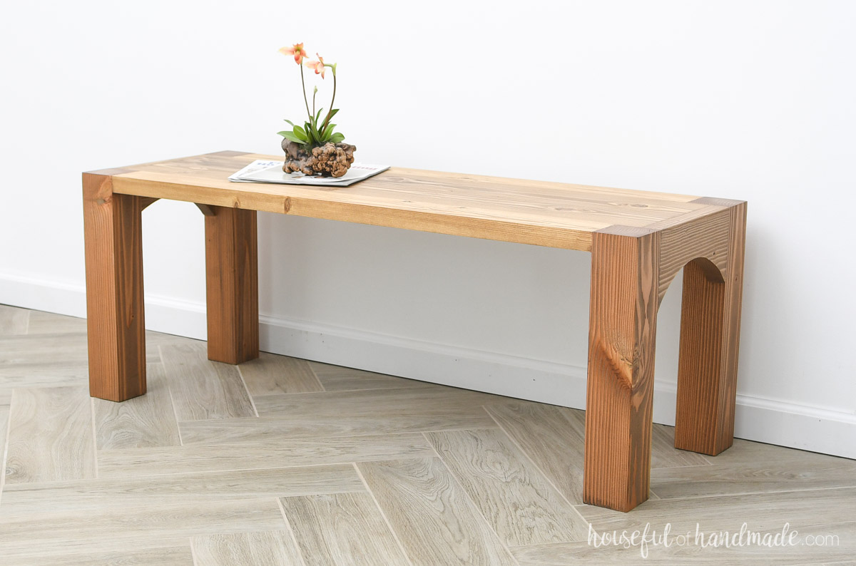 Solid wood single shelf coffee table with arches between the legs on the sides. 