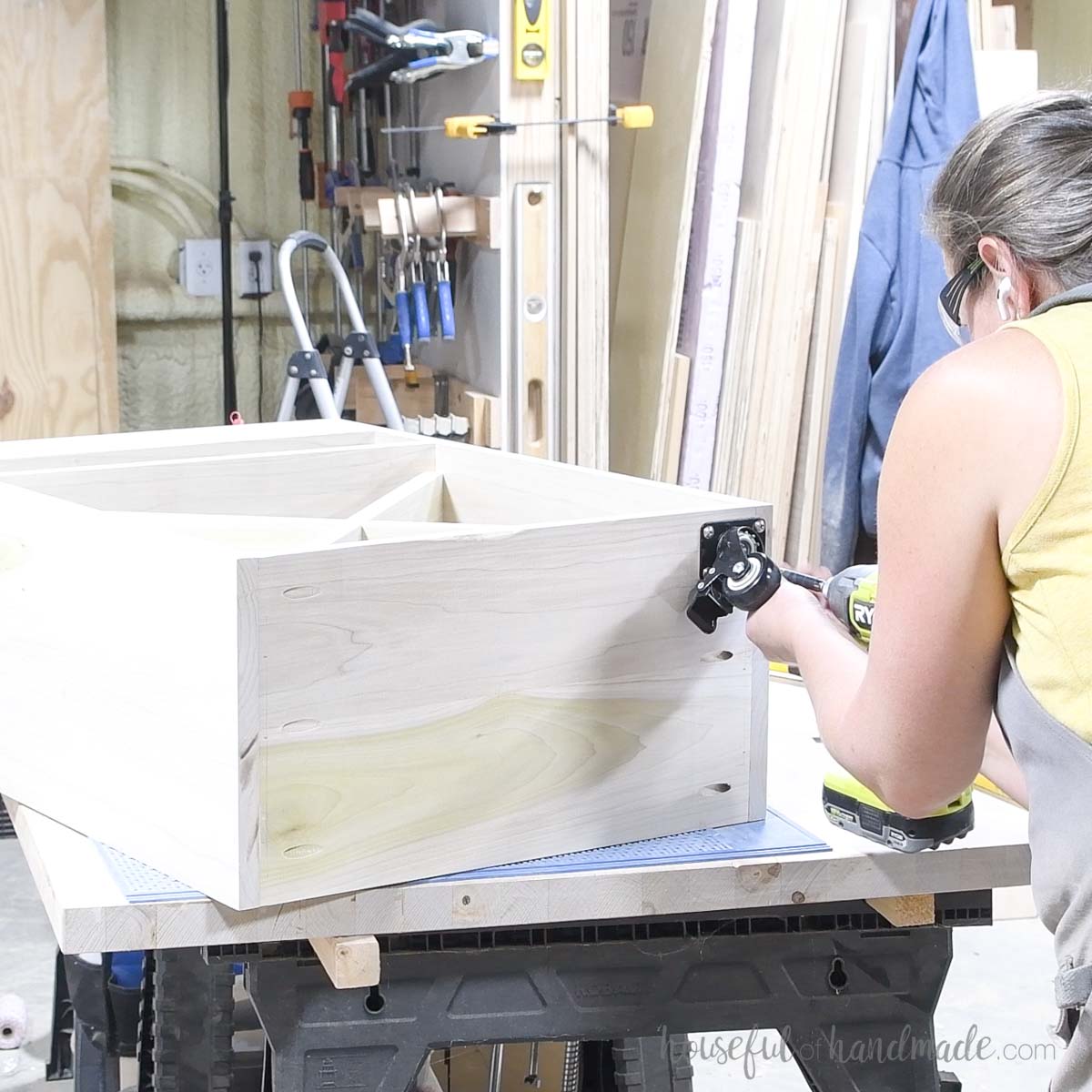 Attaching wheels to the bottom of the craft cart. 