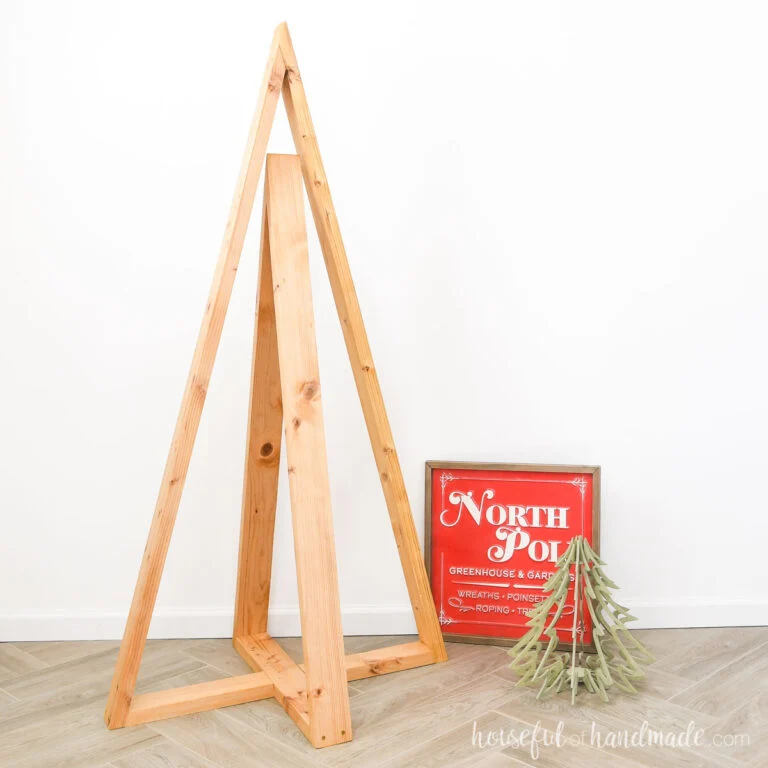 Two intersecting wood triangles making a large wood Christmas tree decoration.