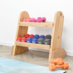 Small DIY wood weight rack with colorful dumbbells on it.