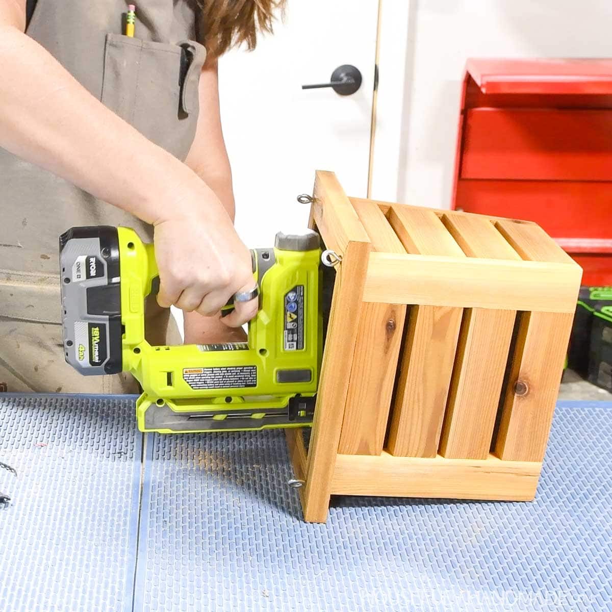 Stapling landscape fabric inside the wood planter. 