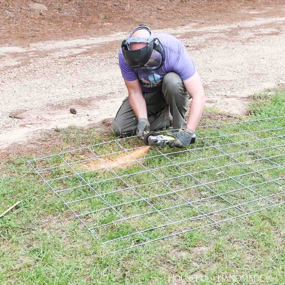 Cutting a cattle panel with an angle grinder.