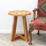 Octagon side table with pedestal legs sitting next to southwest style chair.