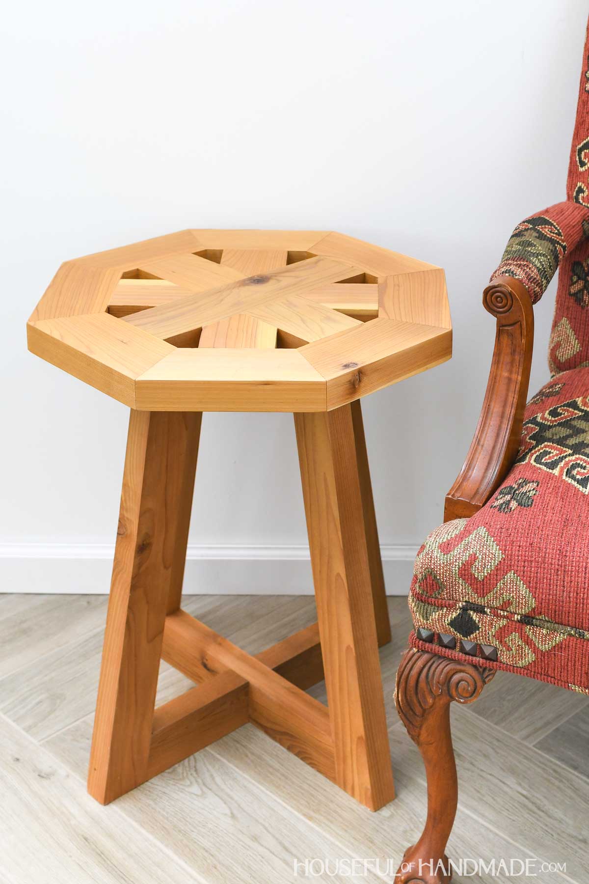 Side table with pedestal legs and octagon top with small holes in the edges.