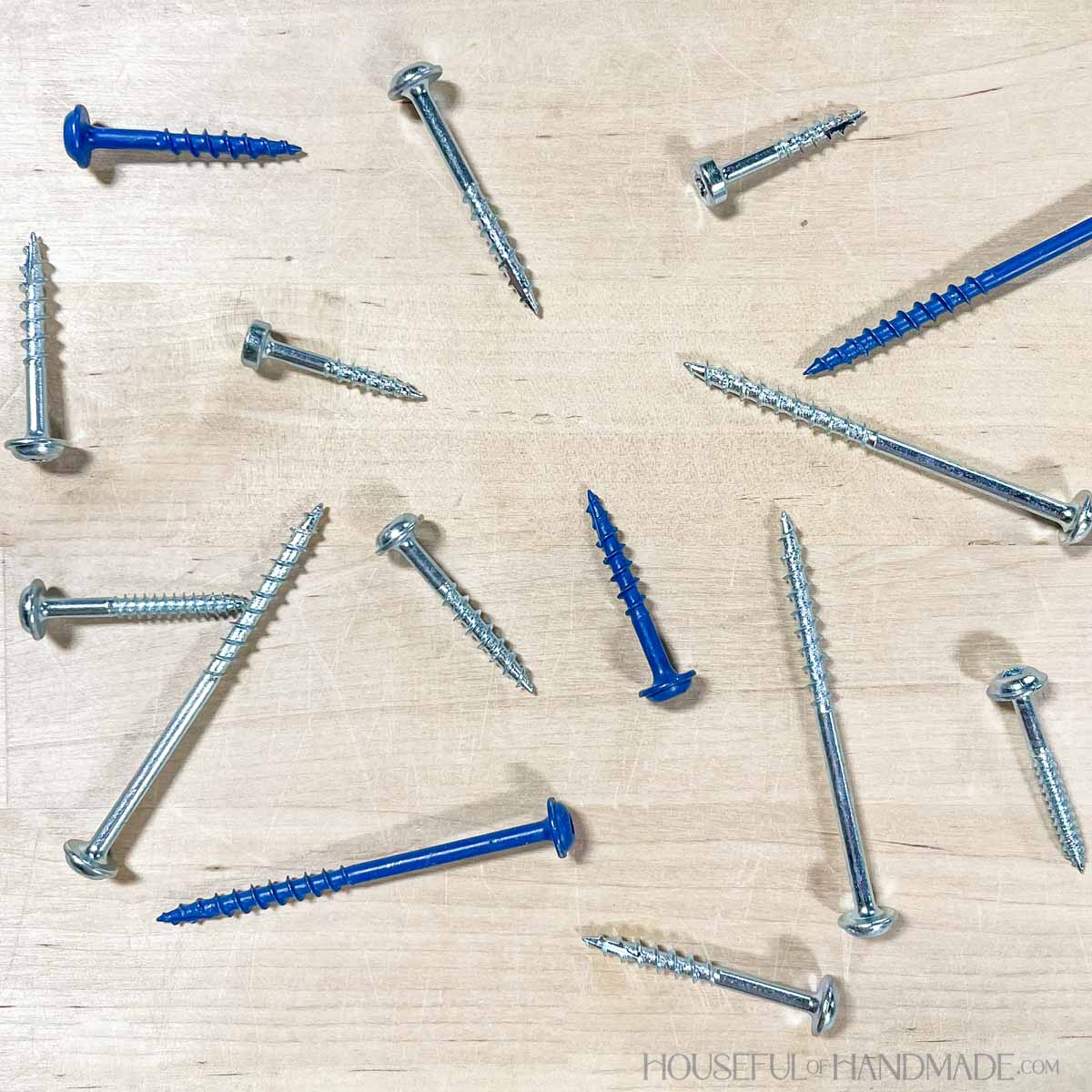 A variety of pocket hole screws sprinkled on a work table.