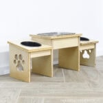 DIY dog bowl stand made from plywood scraps with a paw cut out in the sides.