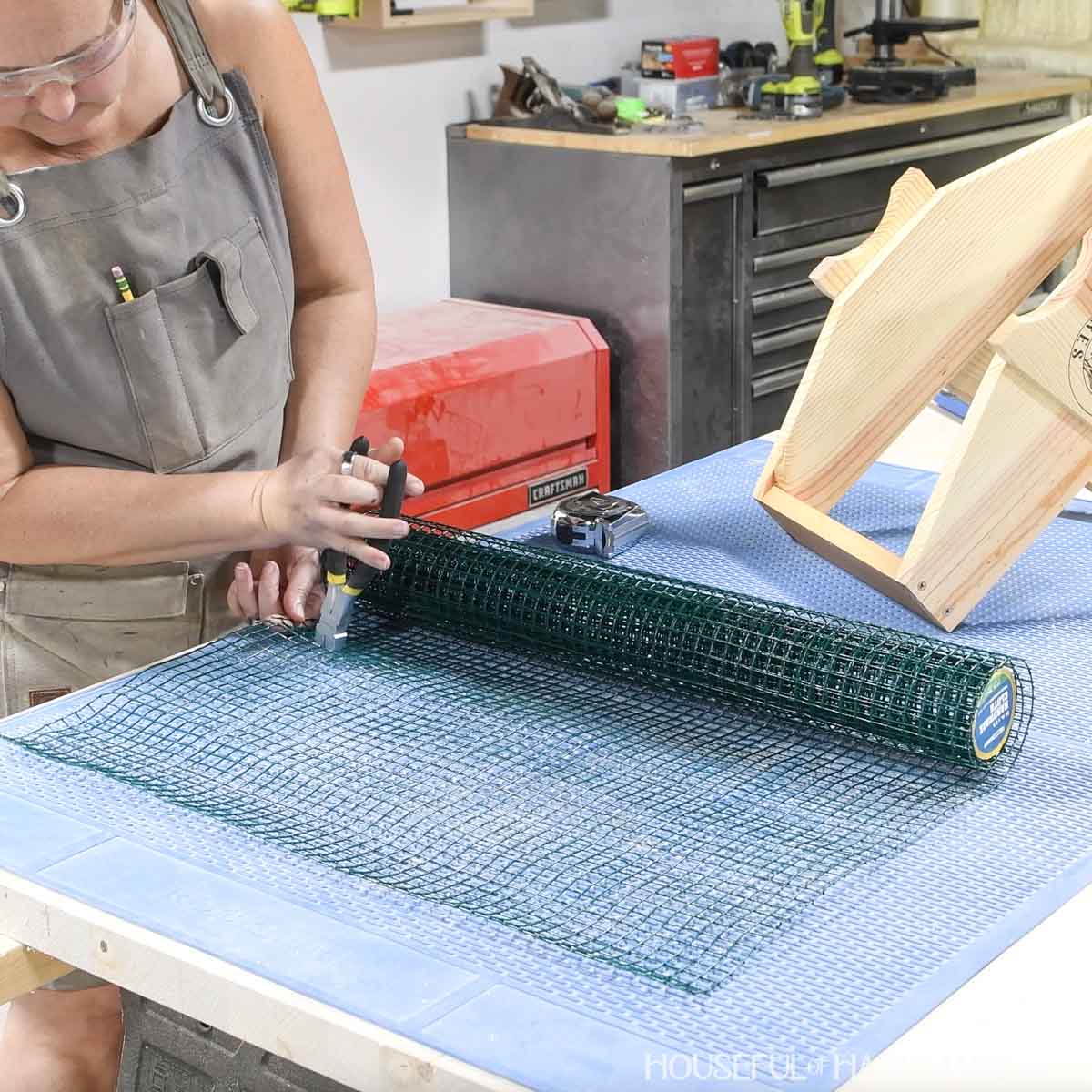 Cutting hardware cloth with pliers.