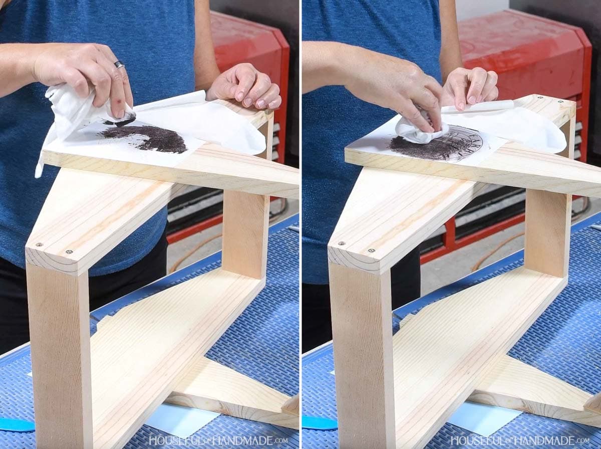 Applying wood stain to the top of a vinyl stencil with a cloth. 