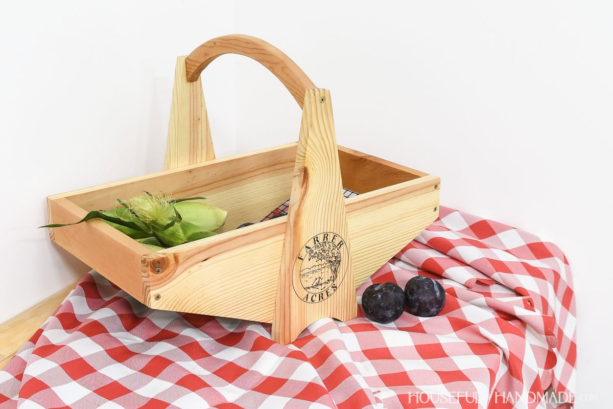 Wood garden basket with wire mesh bottom for gathering vegetables.