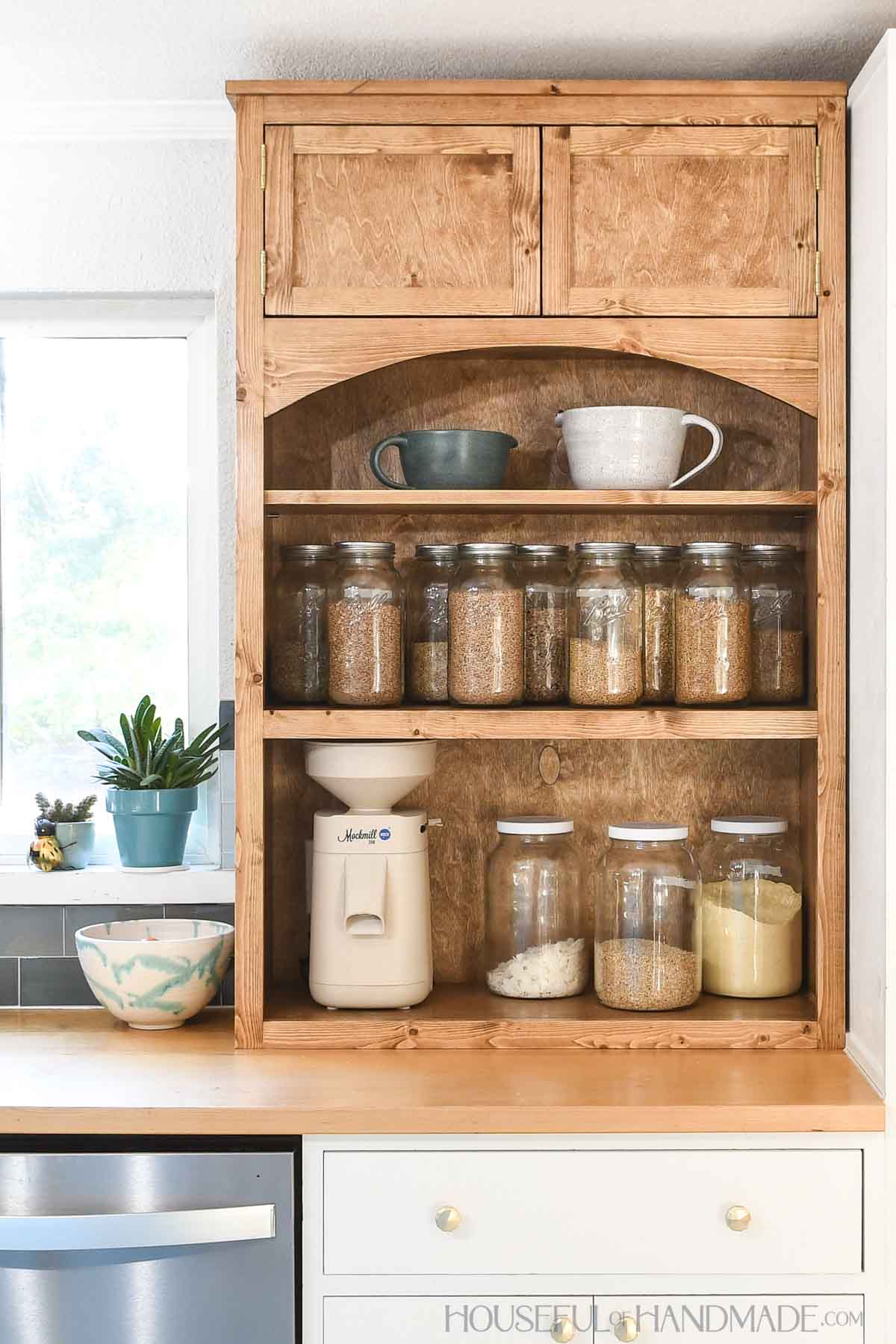 Kitchen hutch with open shelves on bottom and doors on the top sitting on a countertop. 