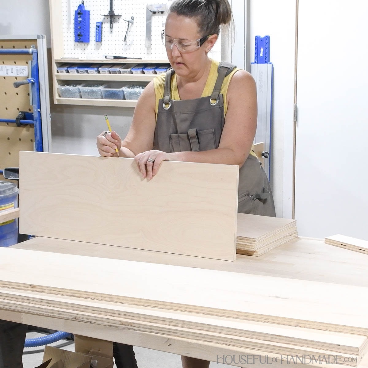 Labeling plywood pieces in woodshop.