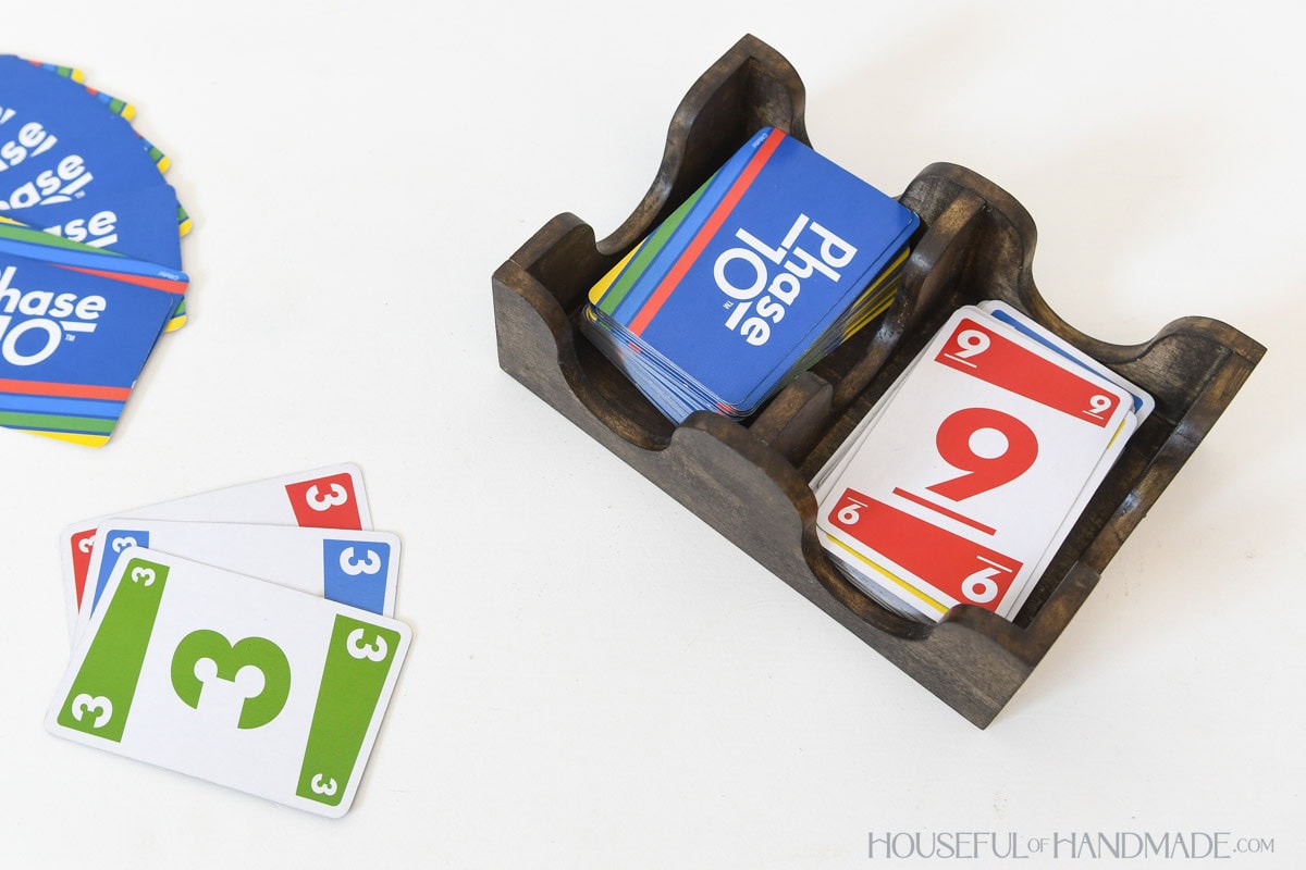 Dark wood card deck caddy for playing cards with Phase 10 cards inside it. 