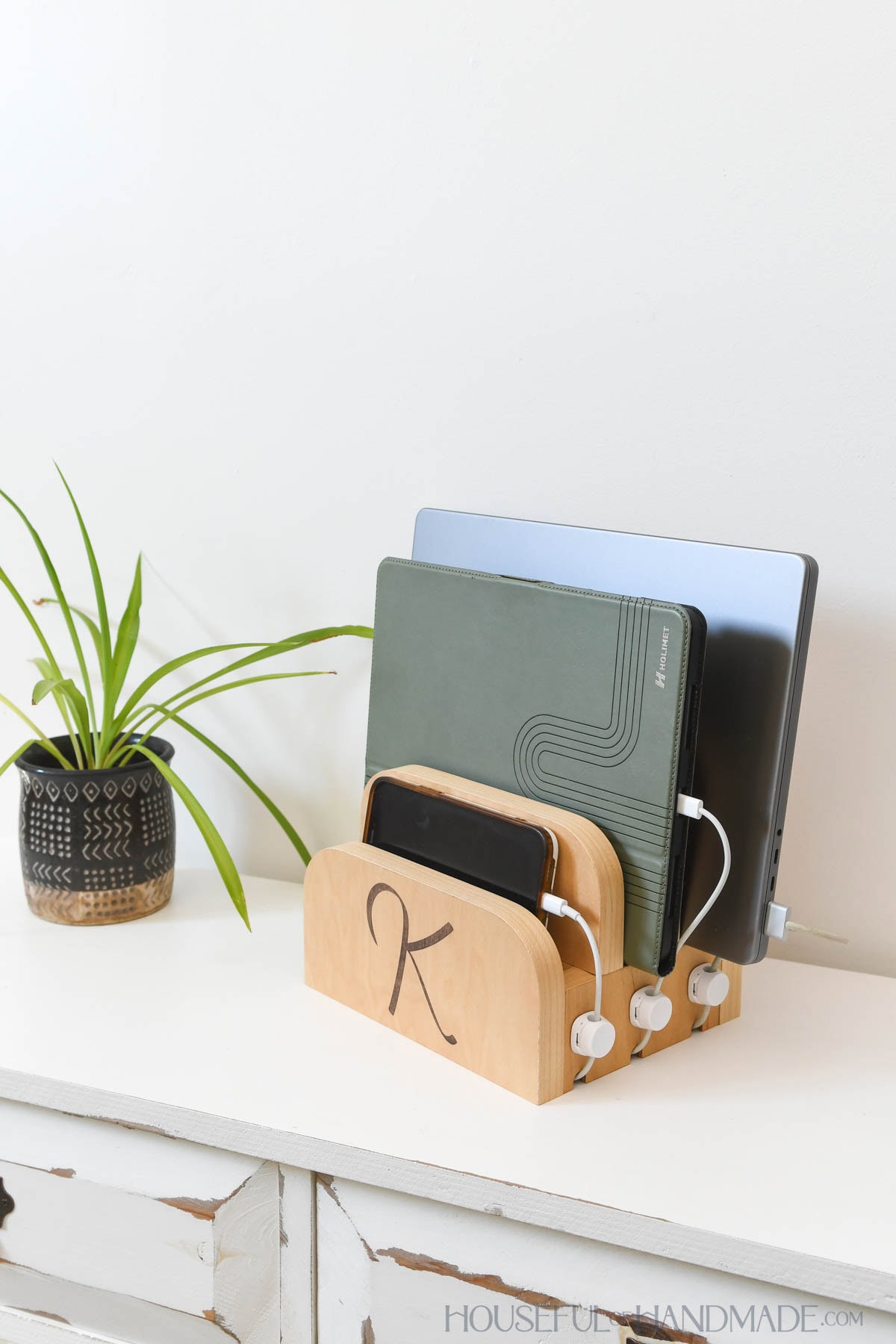 Tabletop charging station made from wood to hold a phone, tablet and laptop.