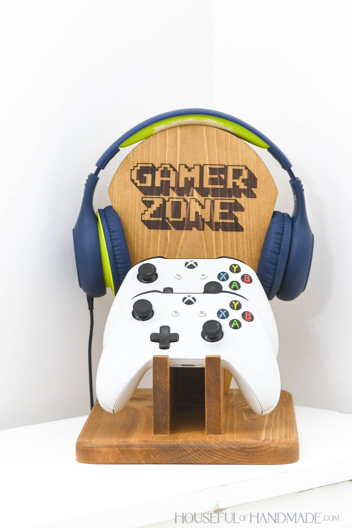 Wood stand for headphones and video game controllers with pixelated "Gamer Zone" design on it.
