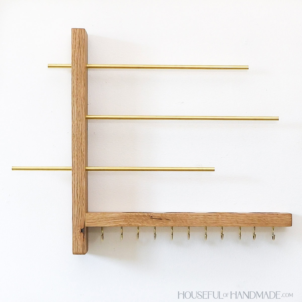 Wood and brass jewelry organizer that mounts on the wall.
