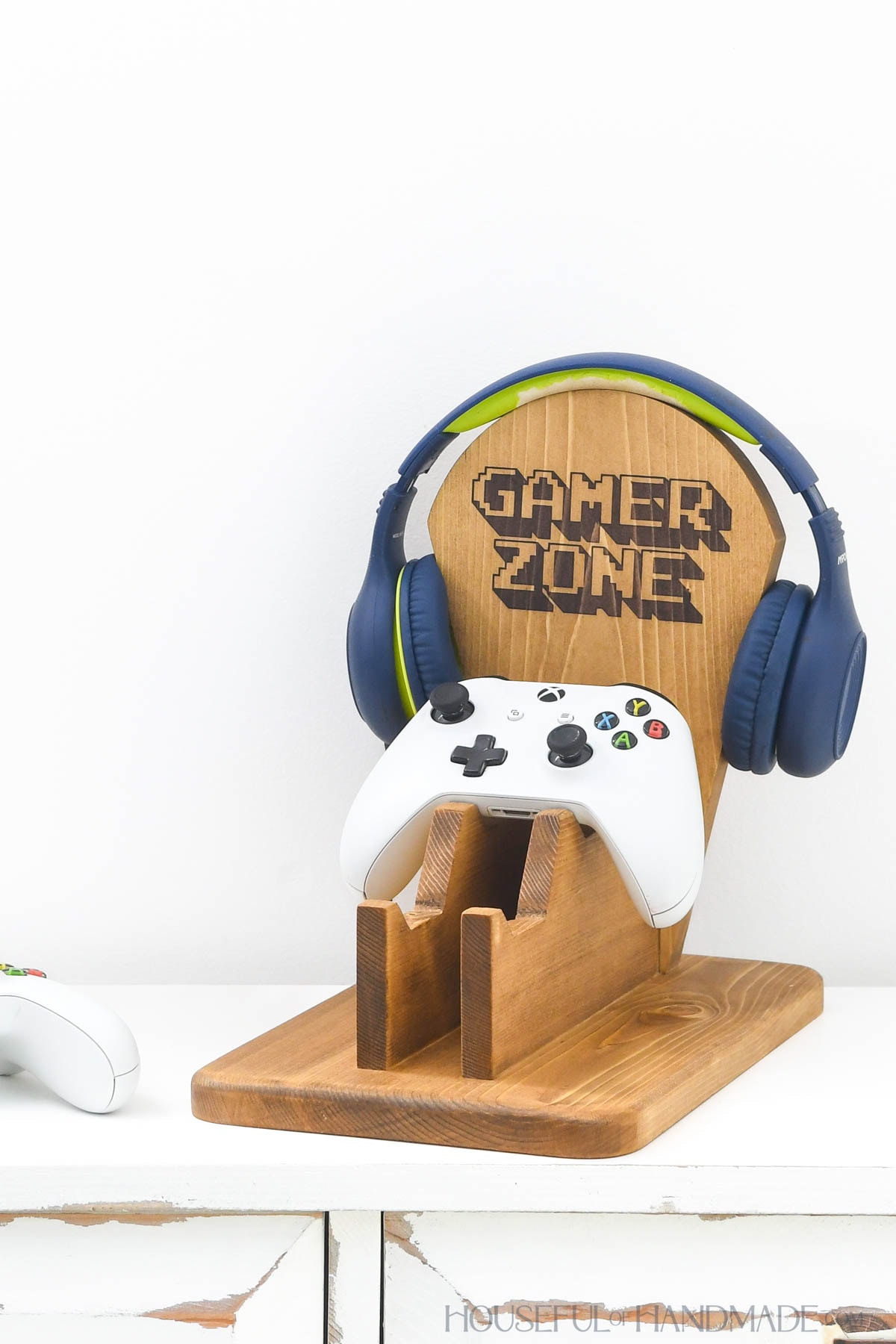 Wood video game controller holder with a spot for headphones on the back.