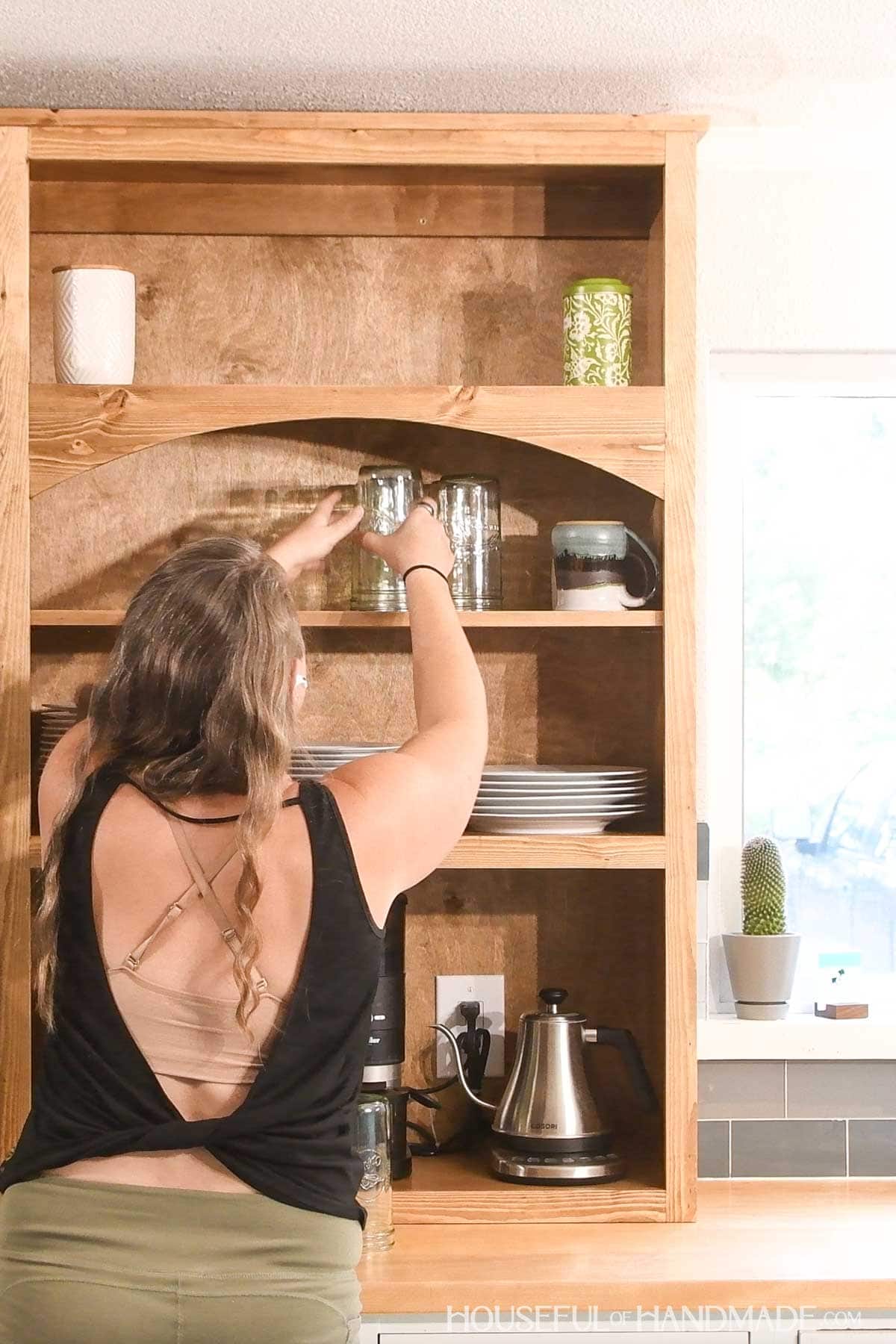Placing dishes on an adjustable shelf.