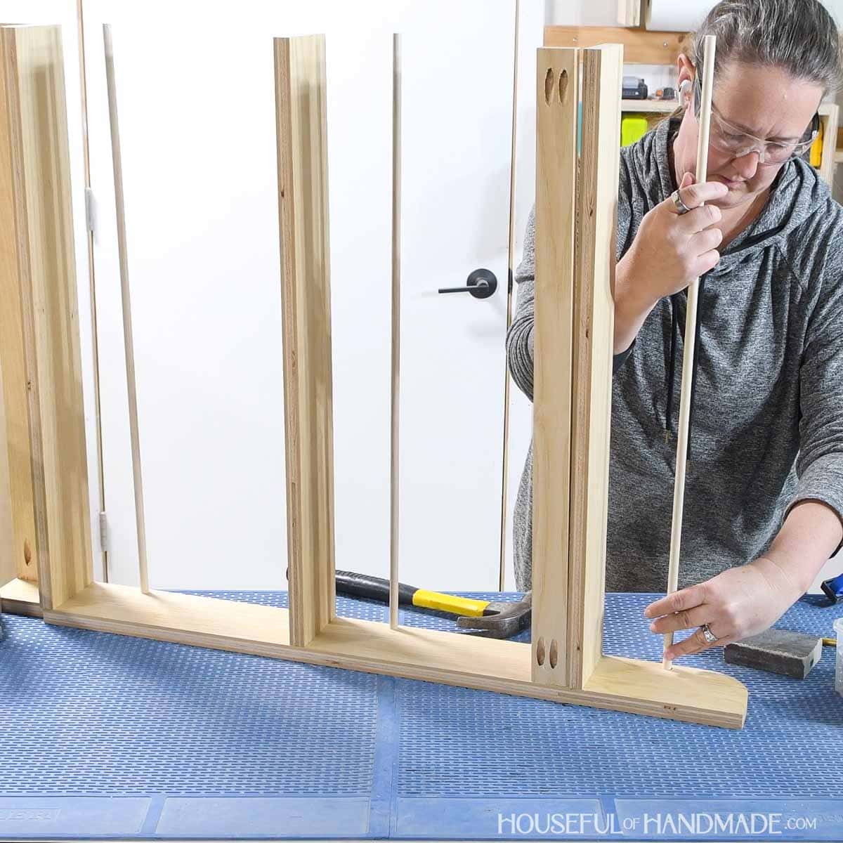 Placing the dowels in the holes drilled in the sides. 