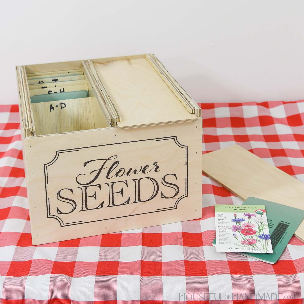 Two compartment seed storage box with flower seed design on the front.