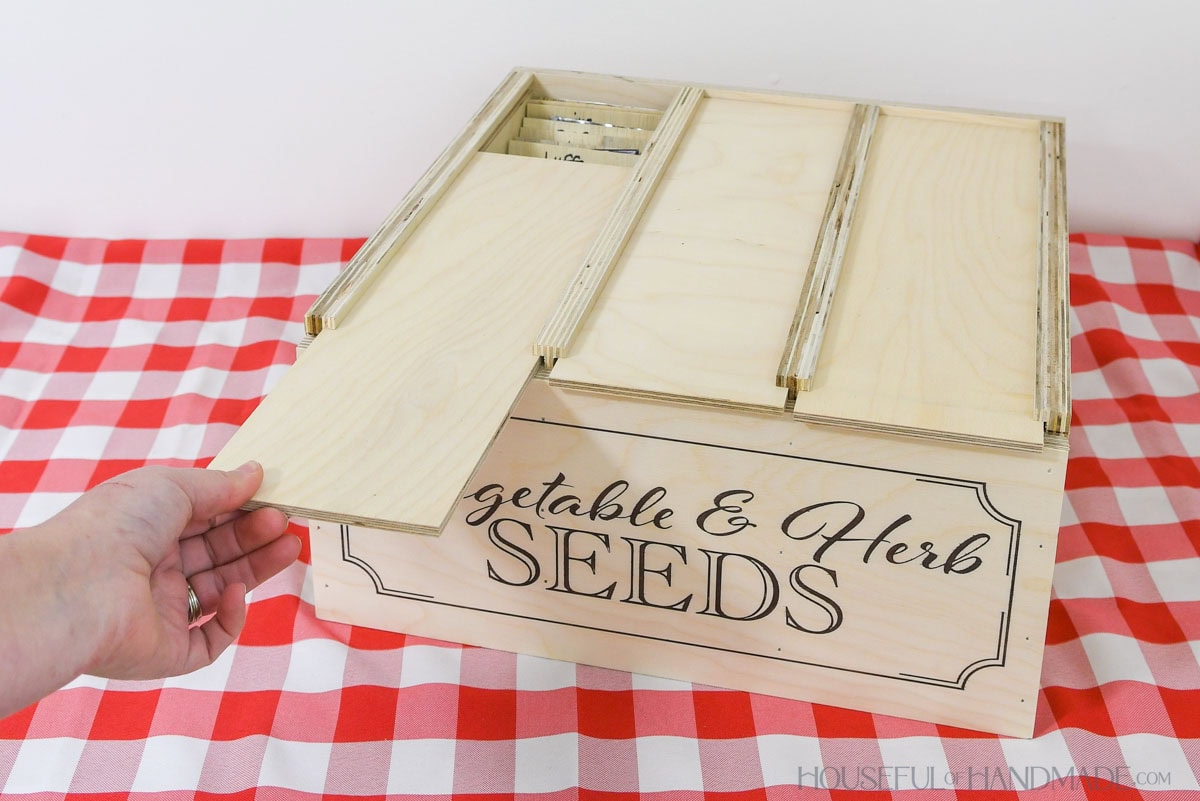 Sliding the top on one section of the seed packet box open.