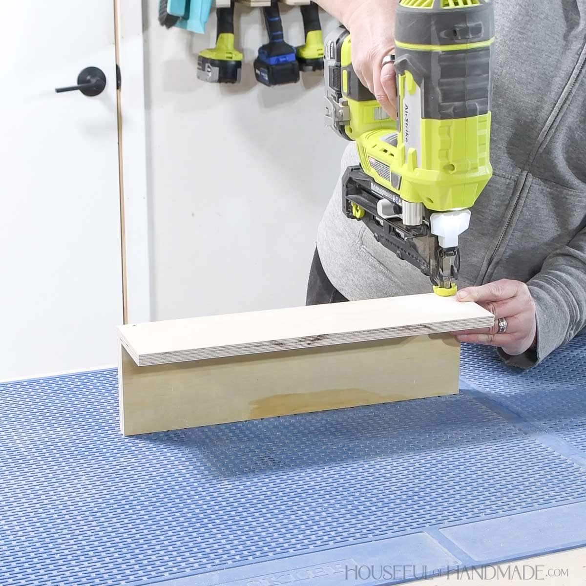 Nailing the front of the small shelf on to the bottom. 