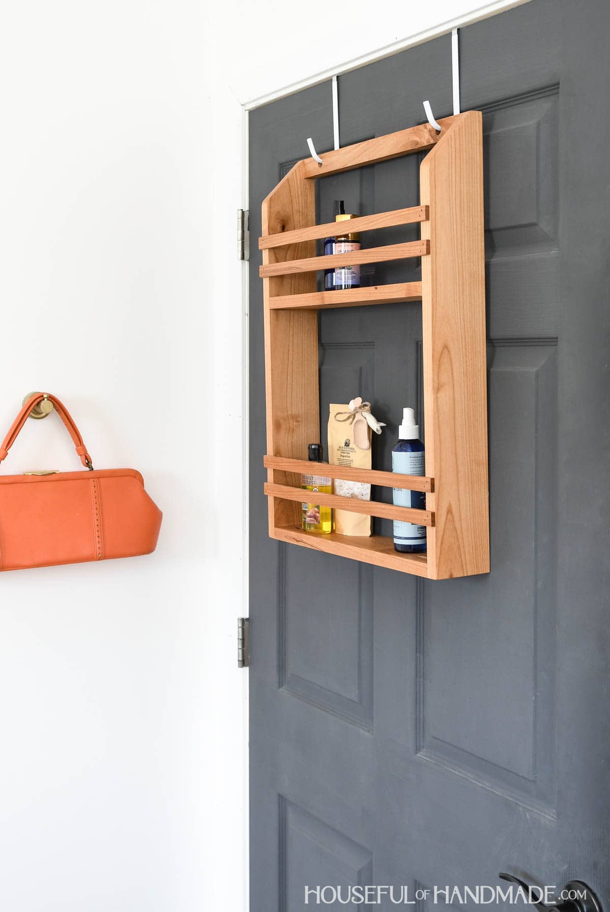 Wood storage shelf hanging on the back of a door.