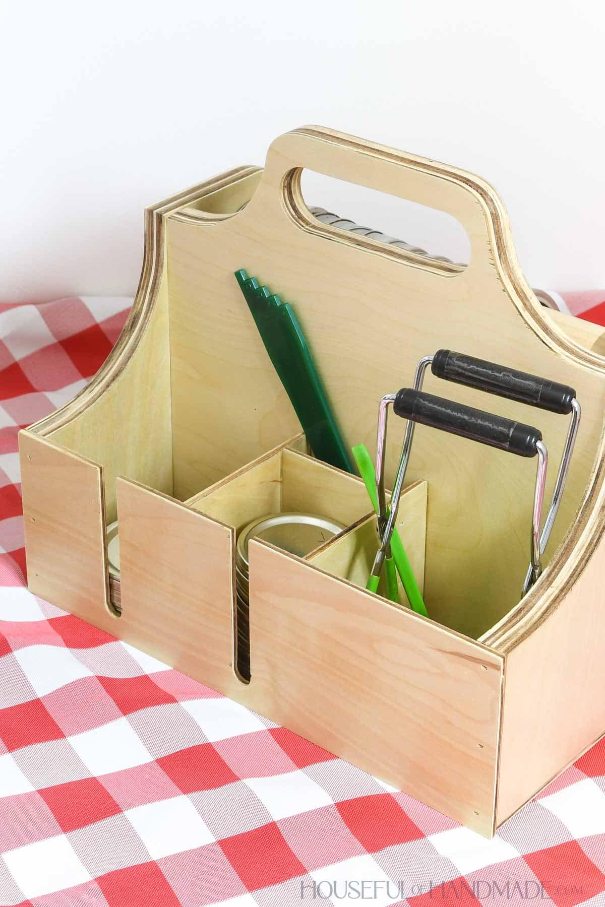 Wood caddy designed to hold canning accessories like lids, rings, jar lifter and more. 