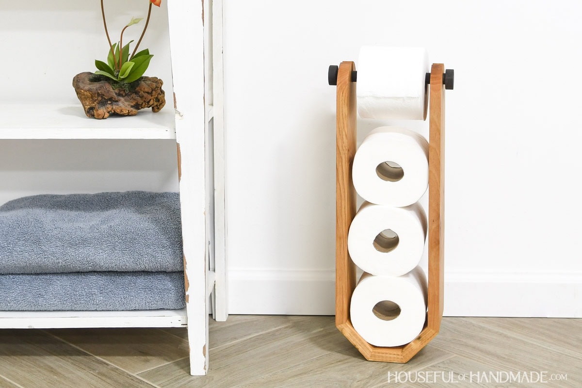 Unique toilet paper holder design with extra space for storage next to bathroom vanity.
