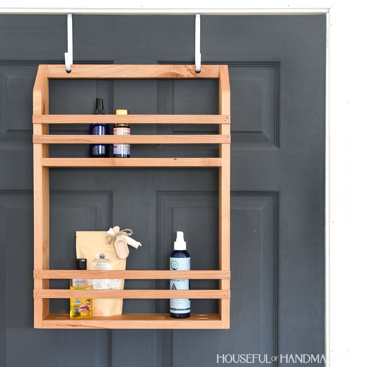 Over the door storage shelf made from scrap wood on a black door.