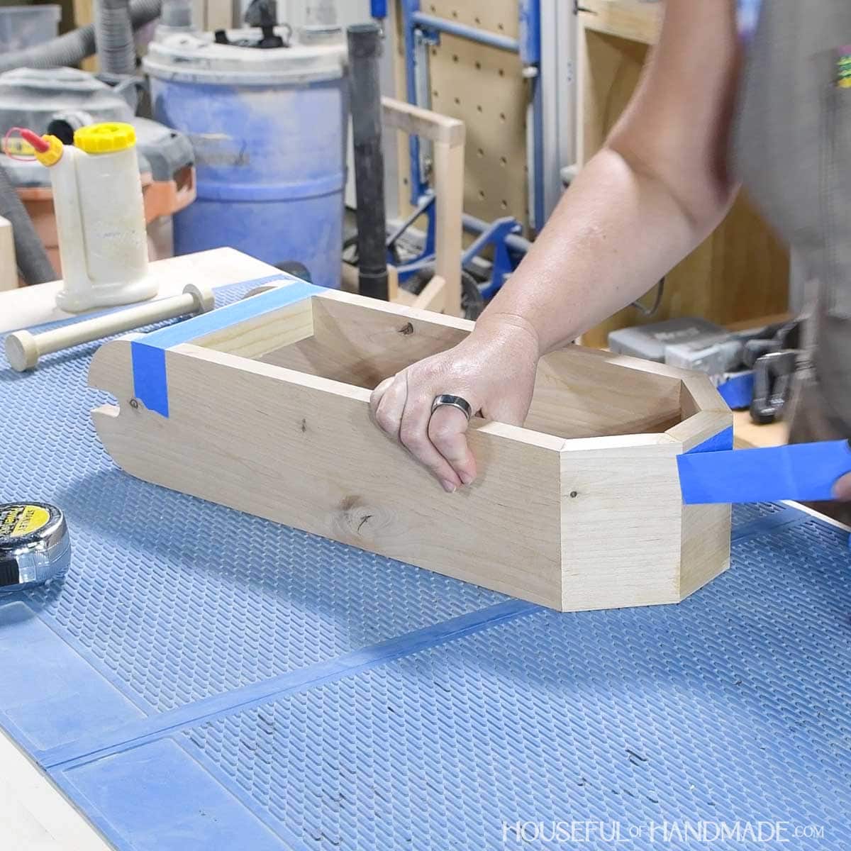 Removing tape from the bottom of the toilet paper stand. 