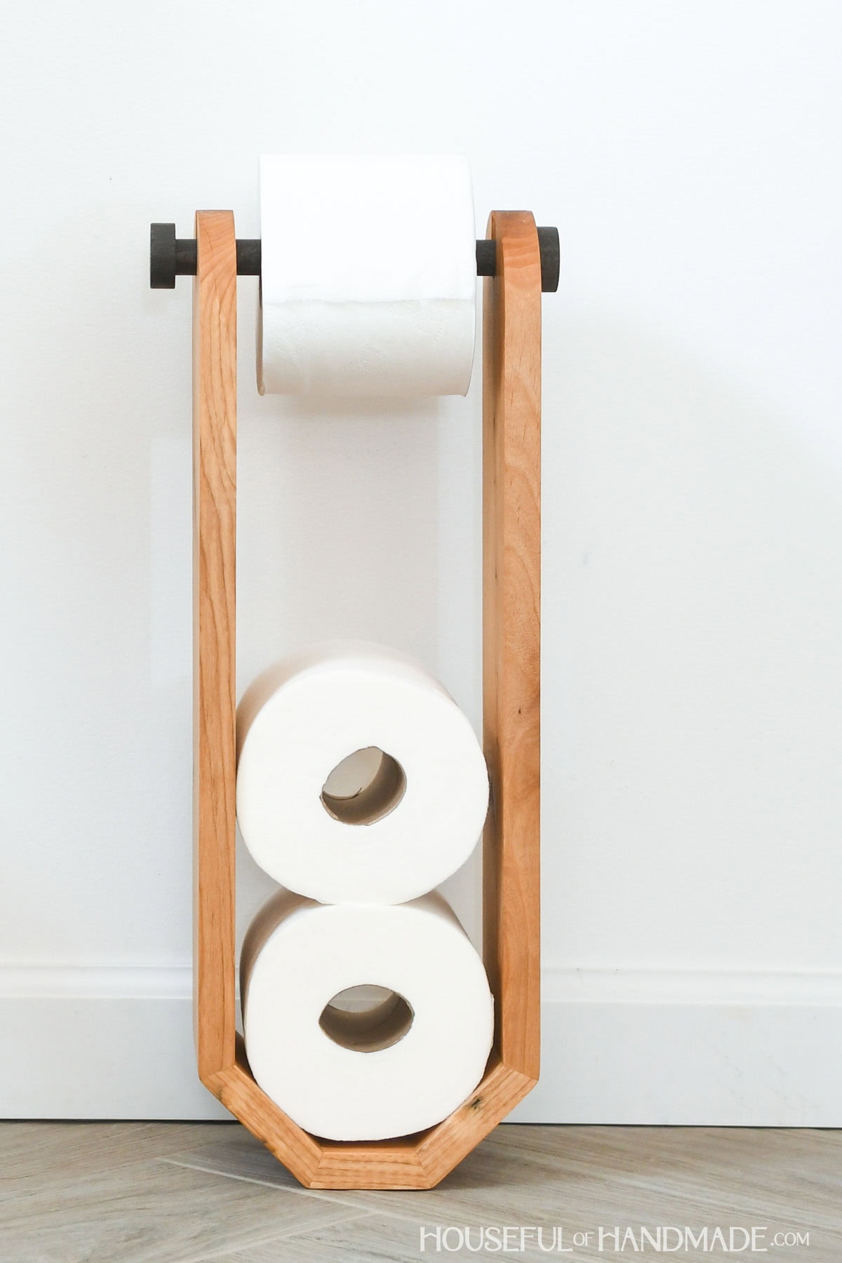 Close up of the freestanding wood toilet paper holder.