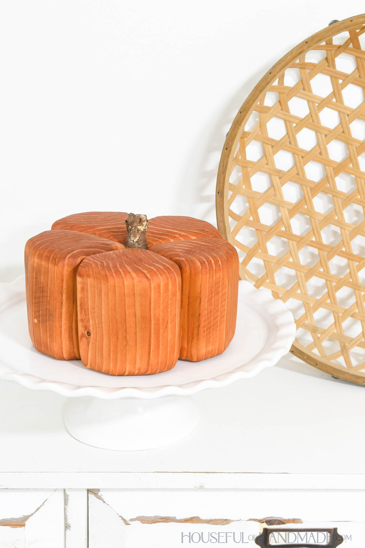 Wood pumpkin on a white cage plate as a display.